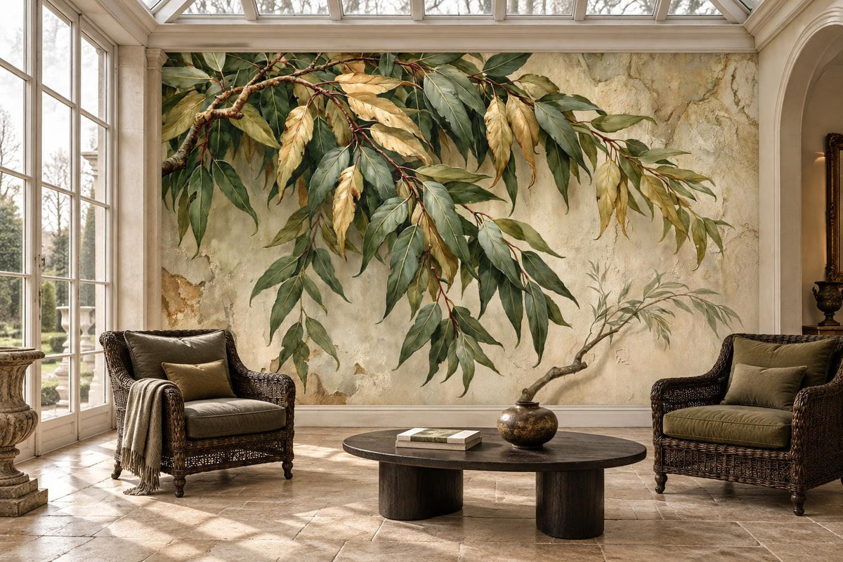 Olive and gold leaf botanical wallpaper mural in a conservatory with wicker armchairs and a round dark coffee table